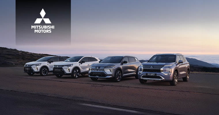 Vier Mitsubishi SUV-Modelle stehen nebeneinander auf einer Straße vor einer Gebirgslandschaft bei Sonnenuntergang; oben links ist das Mitsubishi Motors Logo mit Schriftzug.
